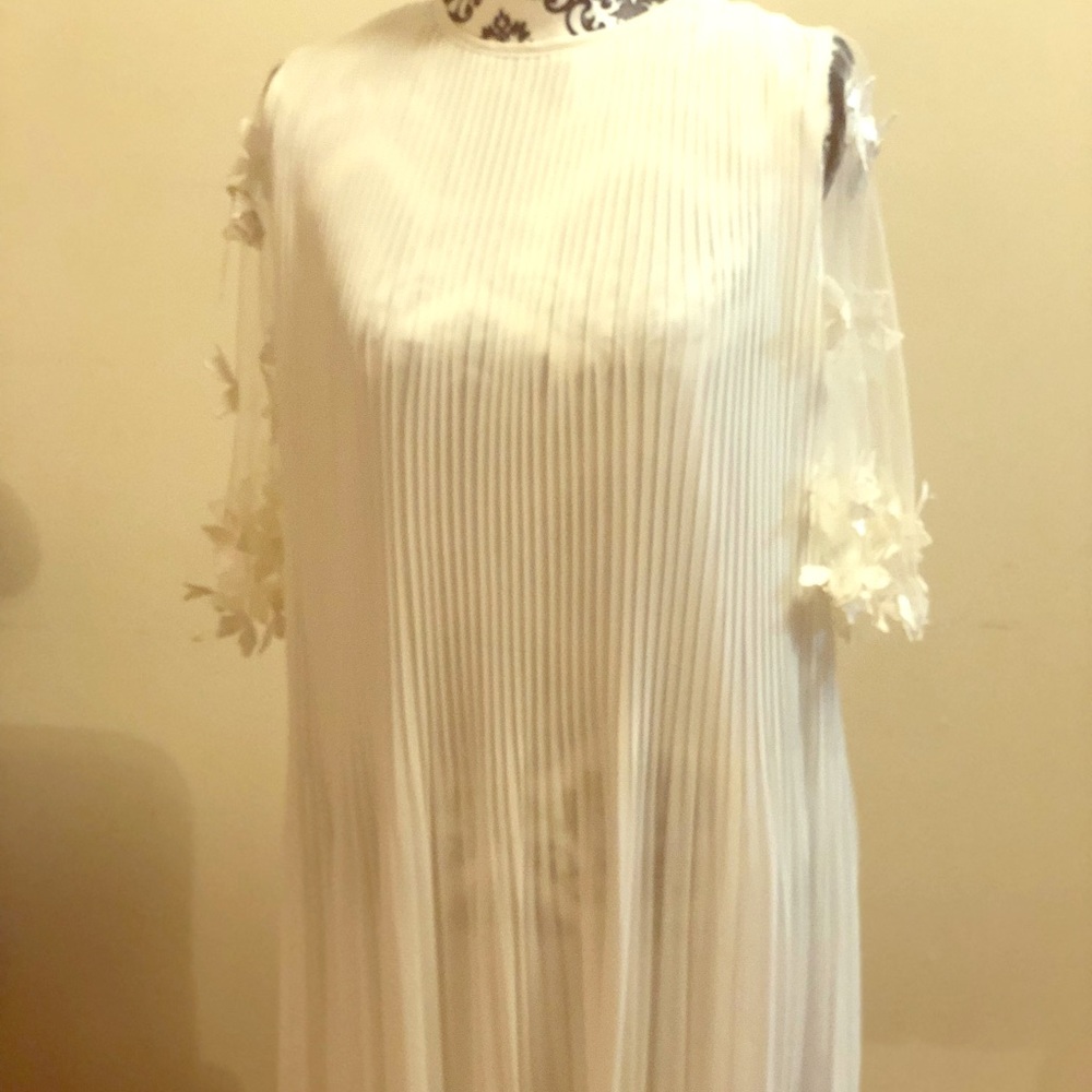 All white dress, with flowers stitched on the arm